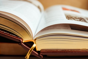 Large open book with golden pages and gold bookmark close up.