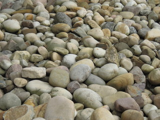 Round stones, background, wallpaper. Closeup view of decorative gravel. Large round tinted pebbles on the beach.