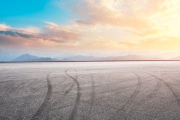Asphalt race track ground and mountain with sunset clouds
