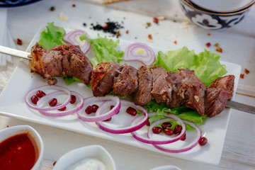 Great meat barbecue on skewer over the white plate, grilled.
