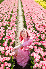 Smiling girl sitting in Tulip field