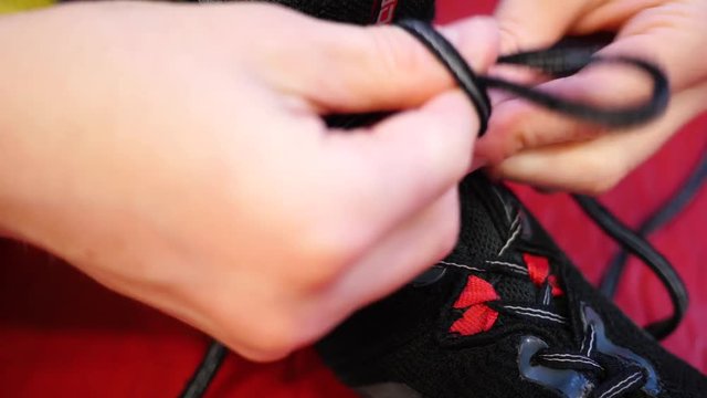 Close up of a person tying the laces on a wrestling shoe