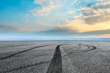 Asphalt race track ground and river with beautiful clouds at sunset