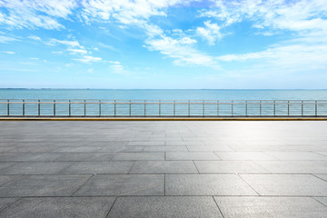 Empty square floor and blue lake with sky clouds