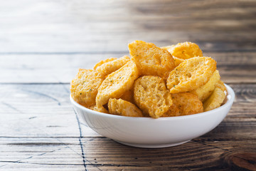 Croutons of white bread baguette with spices in dishes. Wooden background Copy space