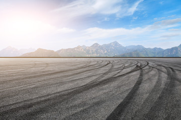 Asphalt race track ground and mountain with clouds background