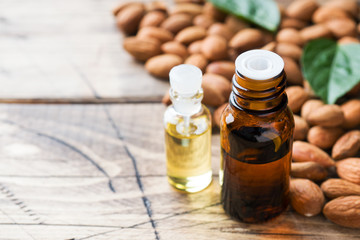 Almond oil in bottle on wooden background. Concept Spa, aromatherapy and medicine. Copy space
