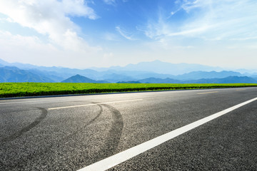 Empty asphalt road and mountains with beautiful clouds landscape