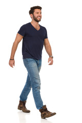 Happy Walking Man In Blue T-shirt, Jeans And Boots Looking Away - 262970113