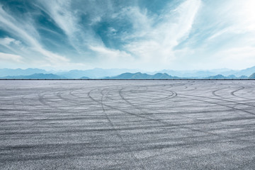 Asphalt race track ground and mountain with clouds background