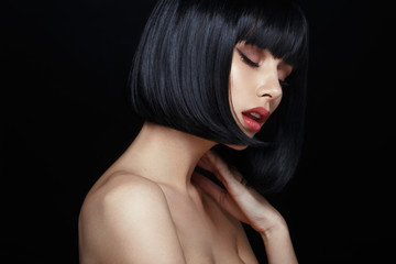 Profile portrait of a sensual young woman in black wig, bob haircuts, she touches his neck, have...