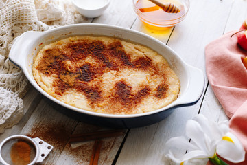 homemade casserole with honey, cinnamon and apples. Wooden white tables. Dessert.