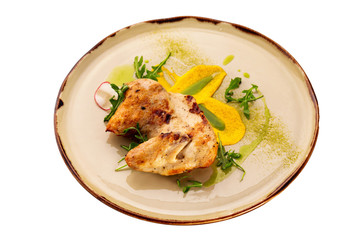 Grilled chicken breast served with sauce on a plate isolated at white background.