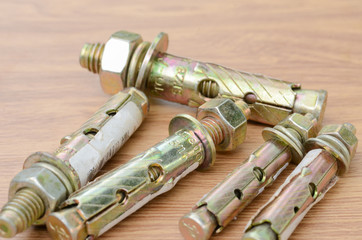 tools and auto spare parts as well as sleeve anchor bolts on a wooden work  bench surface.