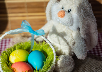 Toy rabbit with a basket of Easter eggs.