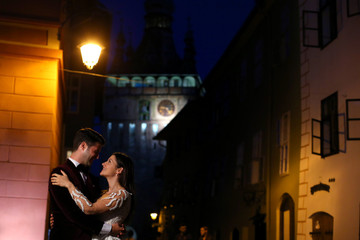 Fototapeta na wymiar Happy beautiful wedding couple posing outdoor in city at night