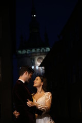 Happy beautiful wedding couple posing outdoor in city at night