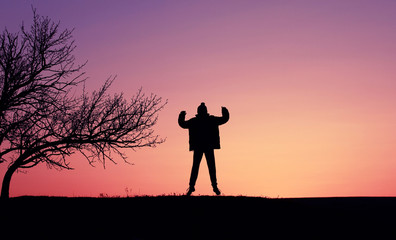 Silhouette of a boy child against the backdrop of a beautiful sunset.