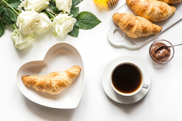 Cup of coffee and freshly baked croissants. Top view. Female breakfast.