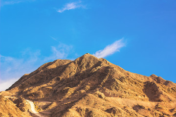 picturesque scenic landscape of desert lonely mountain with small road through sand stone dunes 