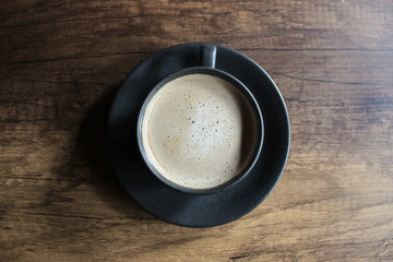 cup of coffee on black background top view