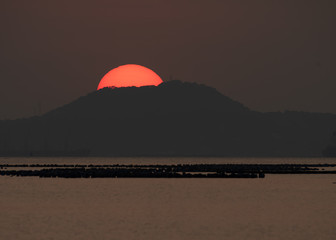Naklejka na ściany i meble Sunset behind the mountains near Laem Chabang Port