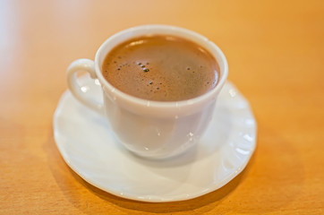 Coffee beans scattered around a cup of coffee.
