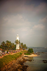 Kolonialer Leuchtturm mit Palmen am Strand von Galle (Sri Lanka)