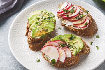 Cereal bread sandwiches with cottage cheese, fresh avocado and radish.