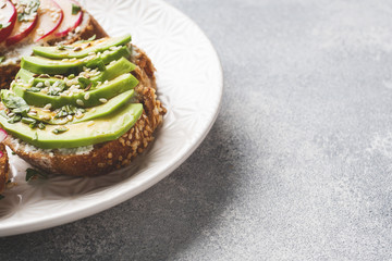 Cereal bread sandwiches with cottage cheese, fresh avocado and radish.