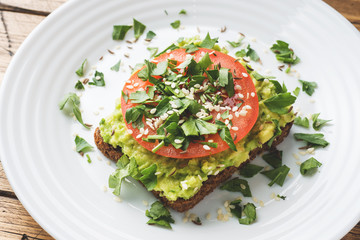 Avocado toast. Healthy toast with avocado mash and tomatoes on a plate.