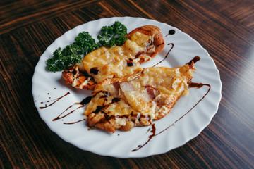 Chicken breast. cheese and onion chopped fritters served with stew green beans and tomatoes on white dish on chopping board