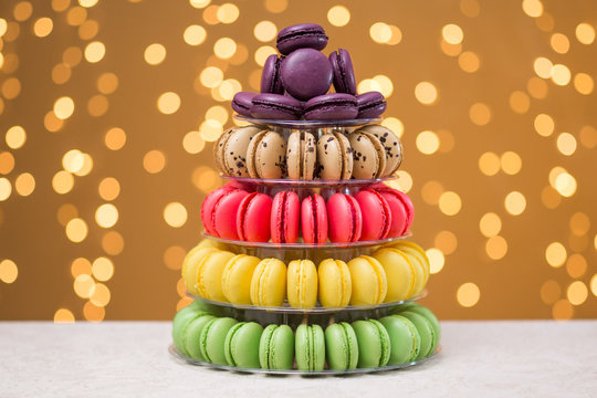 Multicolored macaroons in a shelf on a festive background