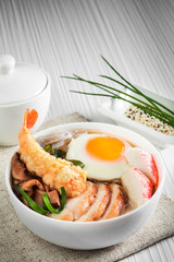 Seafood soup with egg in a white plate.