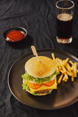 Unhealthy concept. unhealthy food: Burger, sauce, potatoes, cola.
