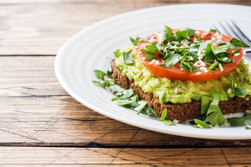 Avocado toast. Healthy toast with avocado mash and tomatoes on a plate.