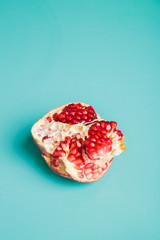 Fresh Pomegranate fruit and seeds on blue color background. Top view. Fruits open with seed. Design concept with space for text and space for design.