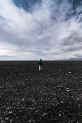 Fototapeta premium man walking on the black beach