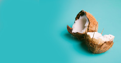 Coconut on a blue background. Half of coconut on turquoise background. Tropical fruit concept.