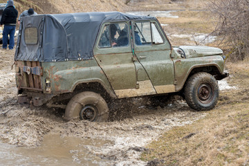 Obraz na płótnie Canvas Russian SUV, Off-road vehicle slips, Stuck in the river 