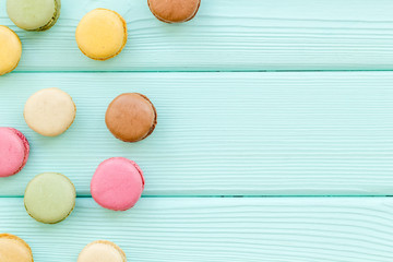Macarons design on mint green wooden background top view space for text
