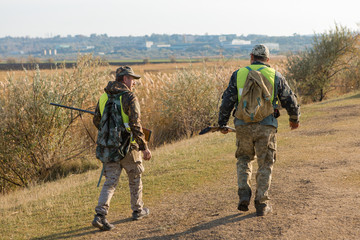 Hunter with a german drathaar and spaniel, pigeon hunting with dogs in reflective vests	