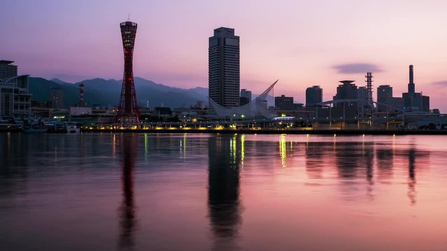 Kobe, Japan. View of sunrise in Kobe, Japan. Time-lapse of cloudless sky with harbor and numerous skyscrapers and Port Tower