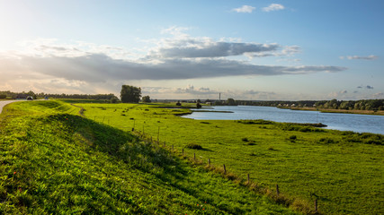 Fototapeta na wymiar open green field landscape with flowing lake