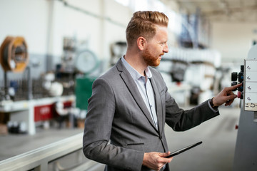 Manager checks machines at the factory.  Inspector checks a factory.  Supervisor runs his daily check at work. Factory worker setting the tech up for work.