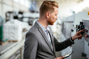 Manager checks machines at the factory.  Inspector checks a factory.  Supervisor runs his daily check at work. Factory worker setting the tech up for work.