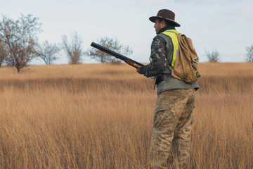 Hunter with a german drathaar and spaniel, pigeon hunting with dogs in reflective vests	