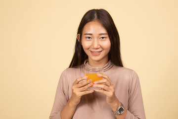 Young Asian woman drink orange juice.