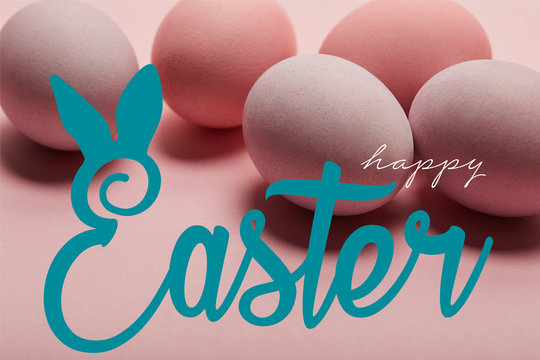 pink painted chicken eggs with blue happy Easter lettering