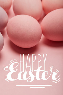 painted pink eggs on pink surface with happy Easter lettering